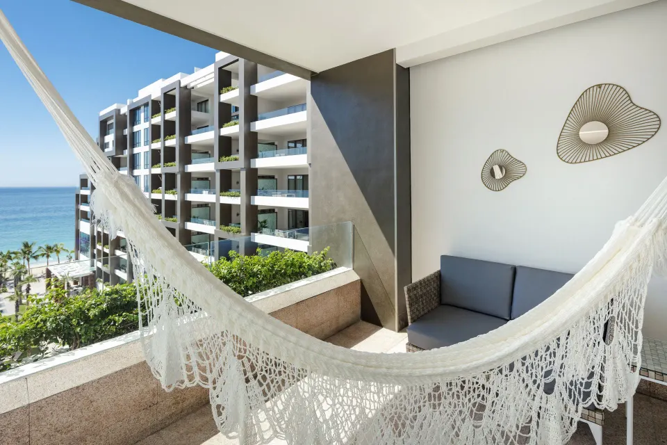Junior Suite Ocean View balcony hammock with ocean and resort building at Garza Blanca Los Cabos.