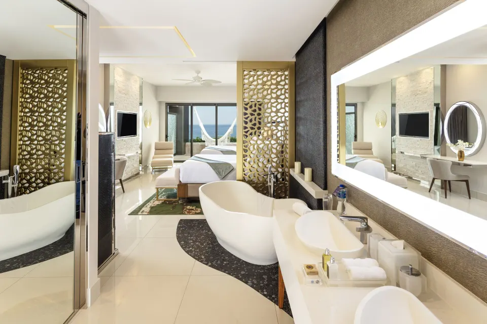 Junior Suite Ocean View bathroom and bedroom with tub and ocean-facing balcony at Garza Blanca Los Cabos.
