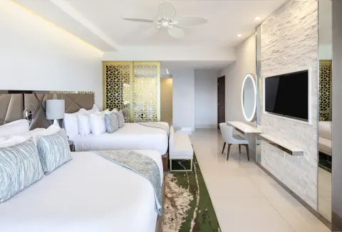 Junior Suite Ocean View two beds with desk, TV, and decorative screen at Garza Blanca Los Cabos.