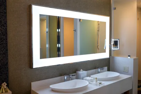 Junior Suite bathroom double vanity with lit mirror and vessel sinks at Garza Blanca Los Cabos.