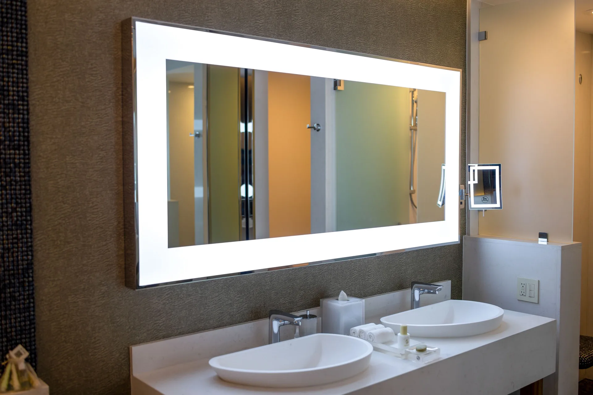 Junior Suite bathroom double vanity with lit mirror and vessel sinks at Garza Blanca Los Cabos.