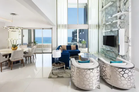 Loft Ocean View lounge with tall windows and dining area at Garza Blanca Los Cabos.