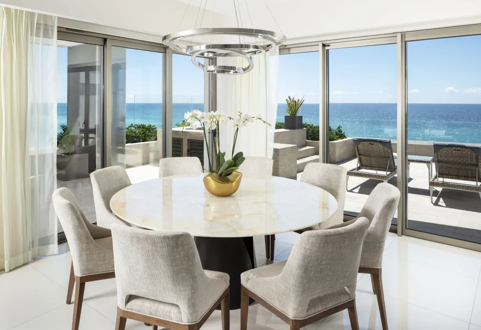Round dining table beside ocean-view windows at Garza Blanca Los Cabos.