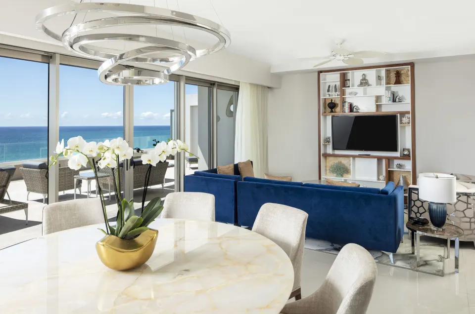 Dining table and blue sofa in an ocean-view suite at Garza Blanca Los Cabos.