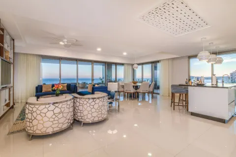 Open living, dining, and kitchen area with ocean views at Garza Blanca Los Cabos.