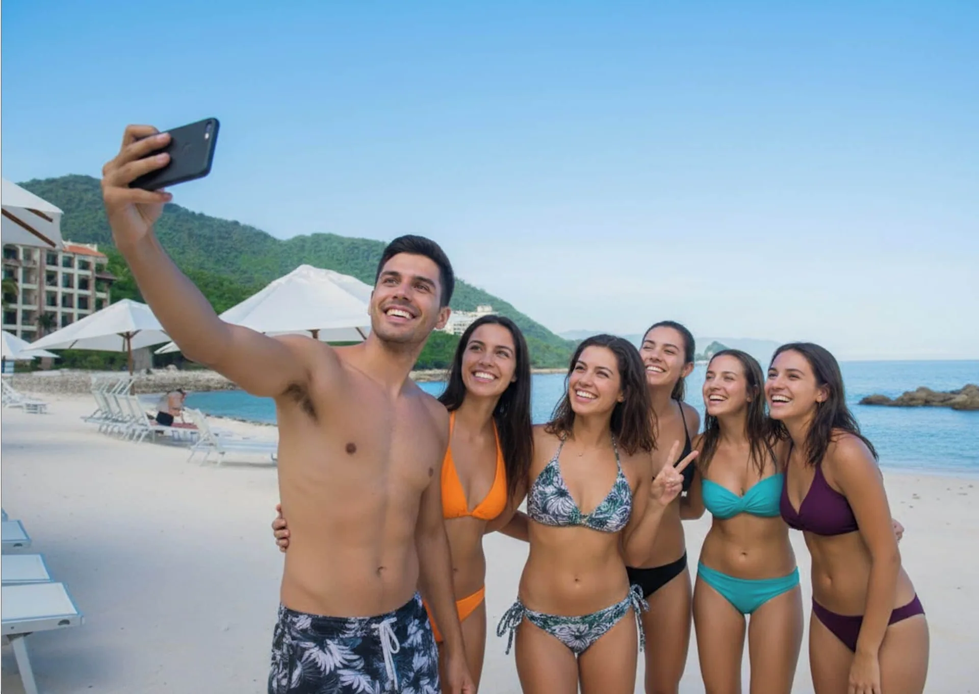 Friends taking a beach selfie near the water at Garza Blanca Preserve Resort & Spa.