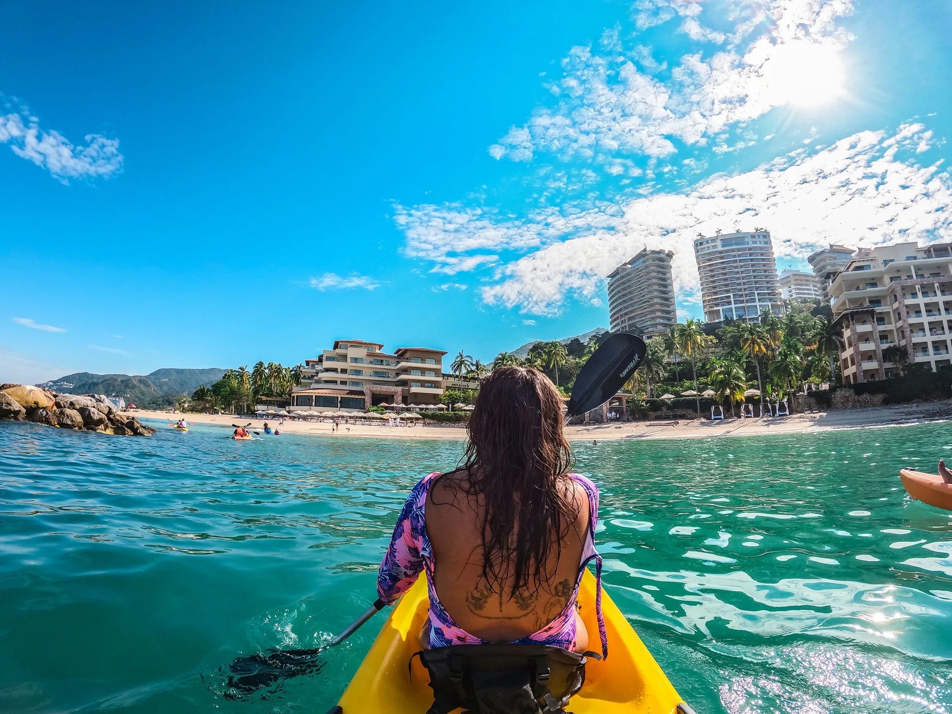 Guest kayaking toward the beachfront at Garza Blanca Preserve Resort & Spa.
