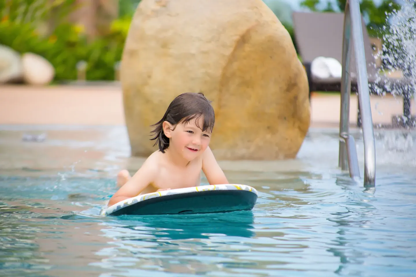 Child floating on a kickboard in the pool at Garza Blanca Preserve Resort & Spa.