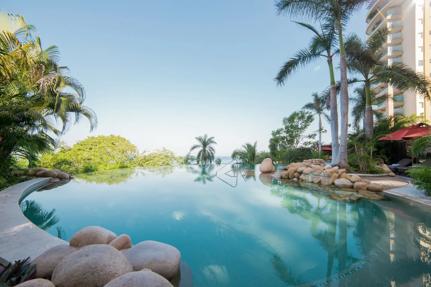 Infinity-edge pool framed by palms and greenery at Garza Blanca Preserve Resort & Spa.