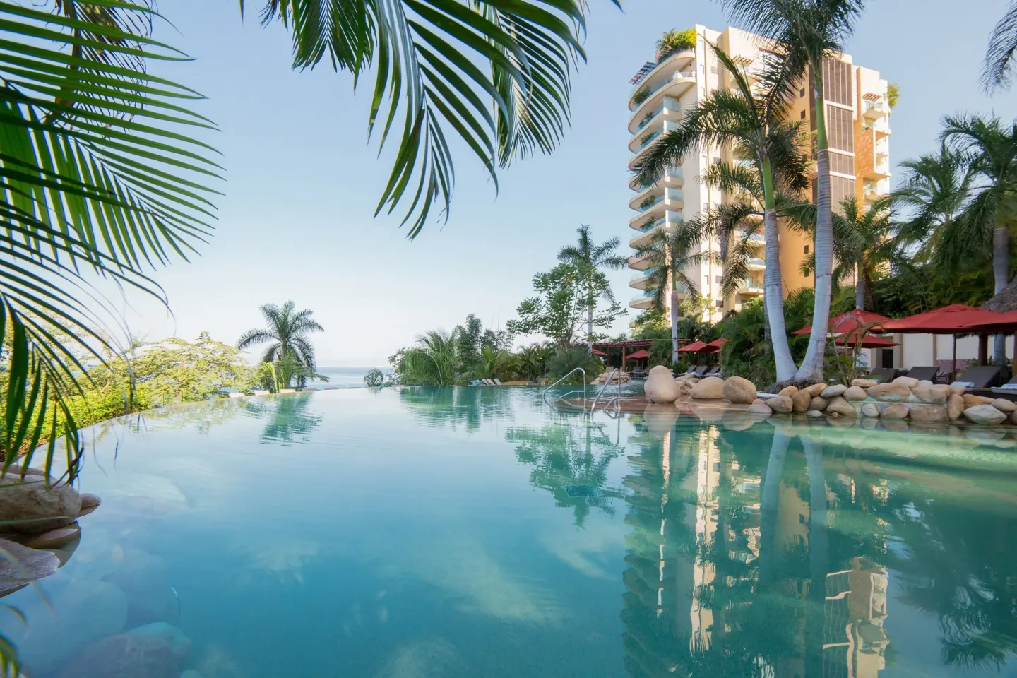 Infinity pool with palms and tower at Garza Blanca Preserve Resort & Spa.