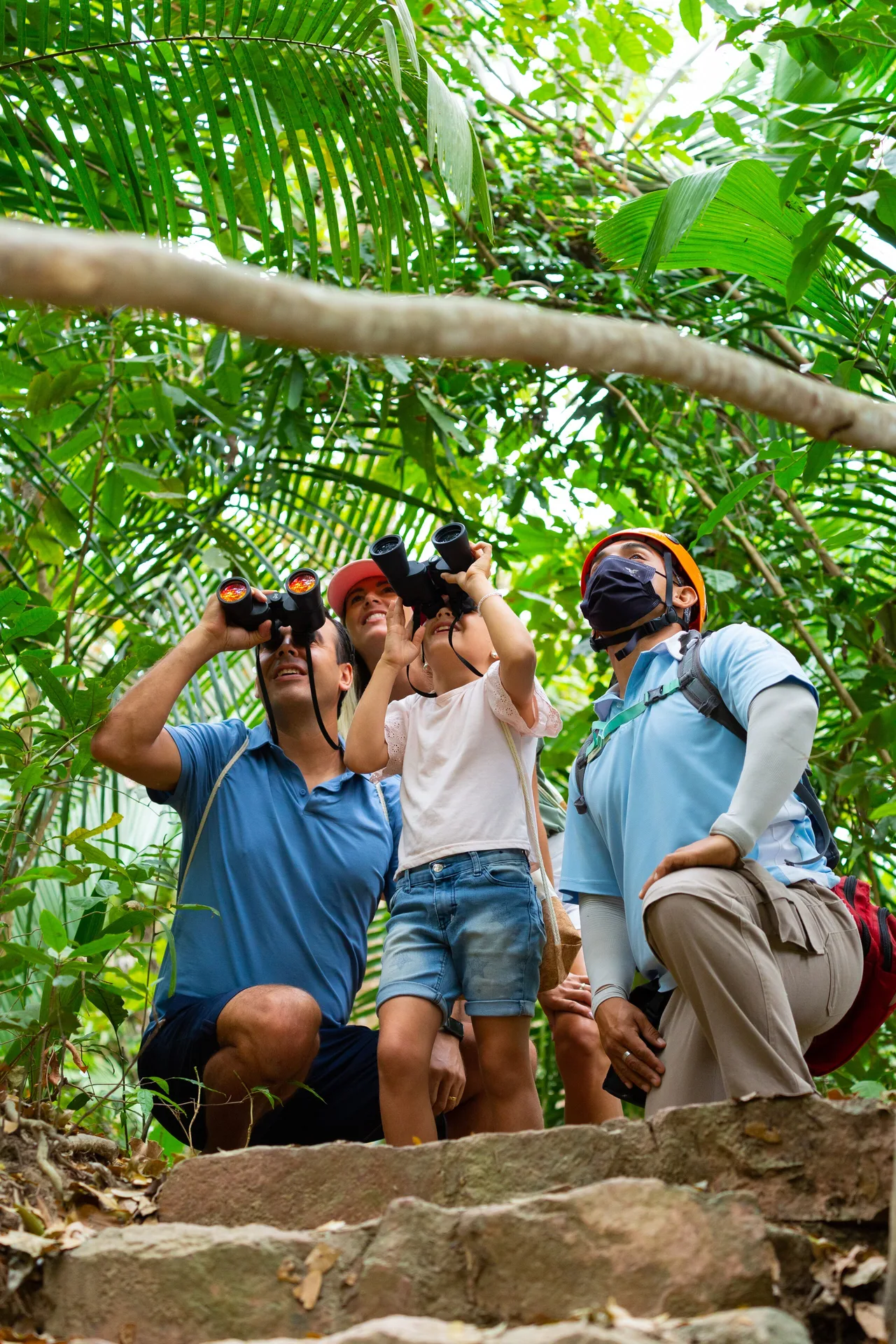 Family birdwatching with binoculars on a jungle path at Garza Blanca Preserve Resort & Spa.