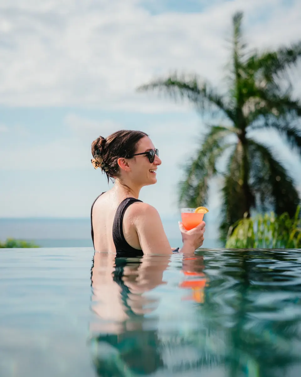 Guest holding a pink drink in the pool at Garza Blanca Preserve Resort & Spa.