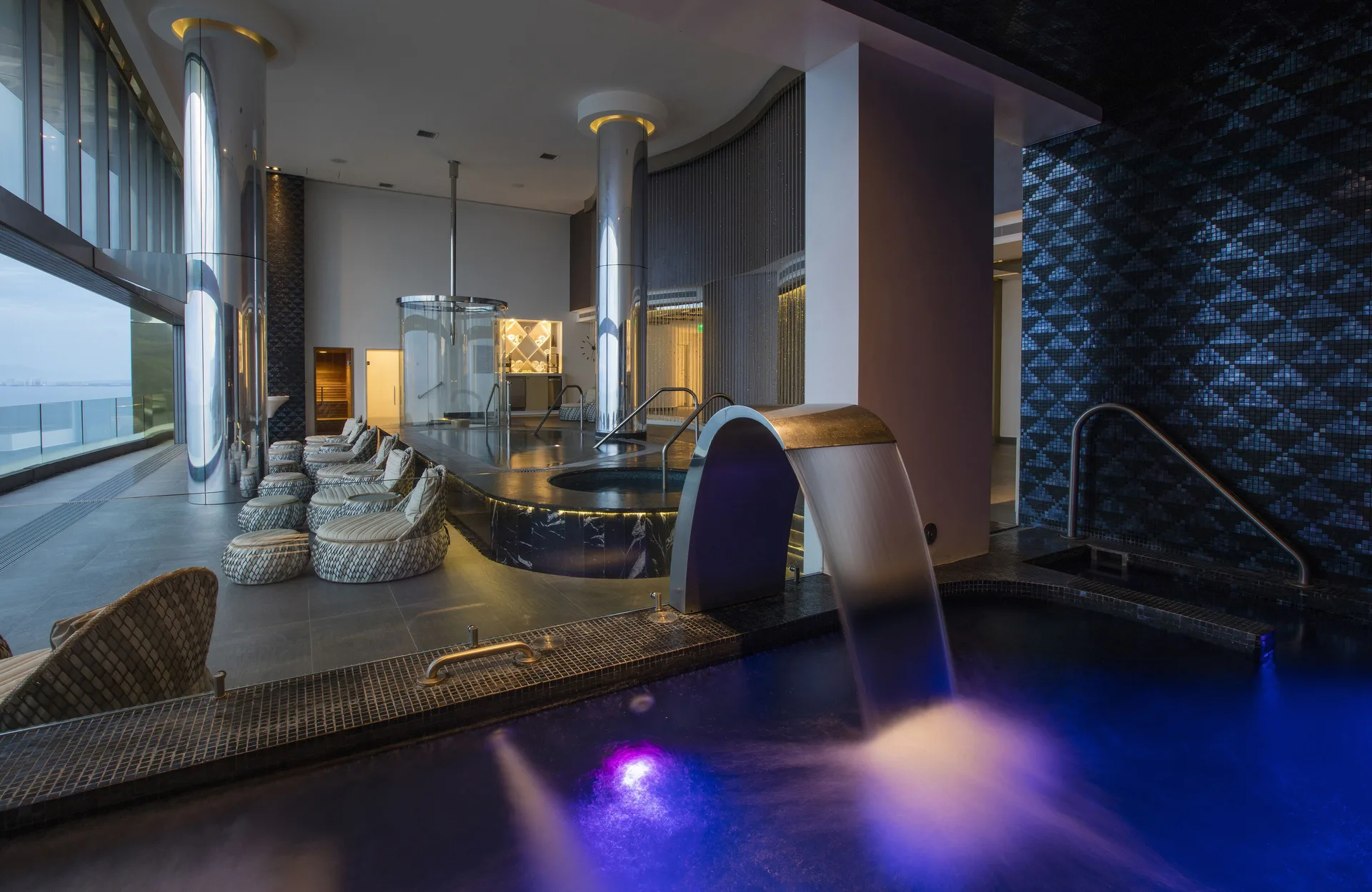 Spa hydrotherapy area with illuminated pool and lounge seating at Garza Blanca Preserve Resort & Spa.