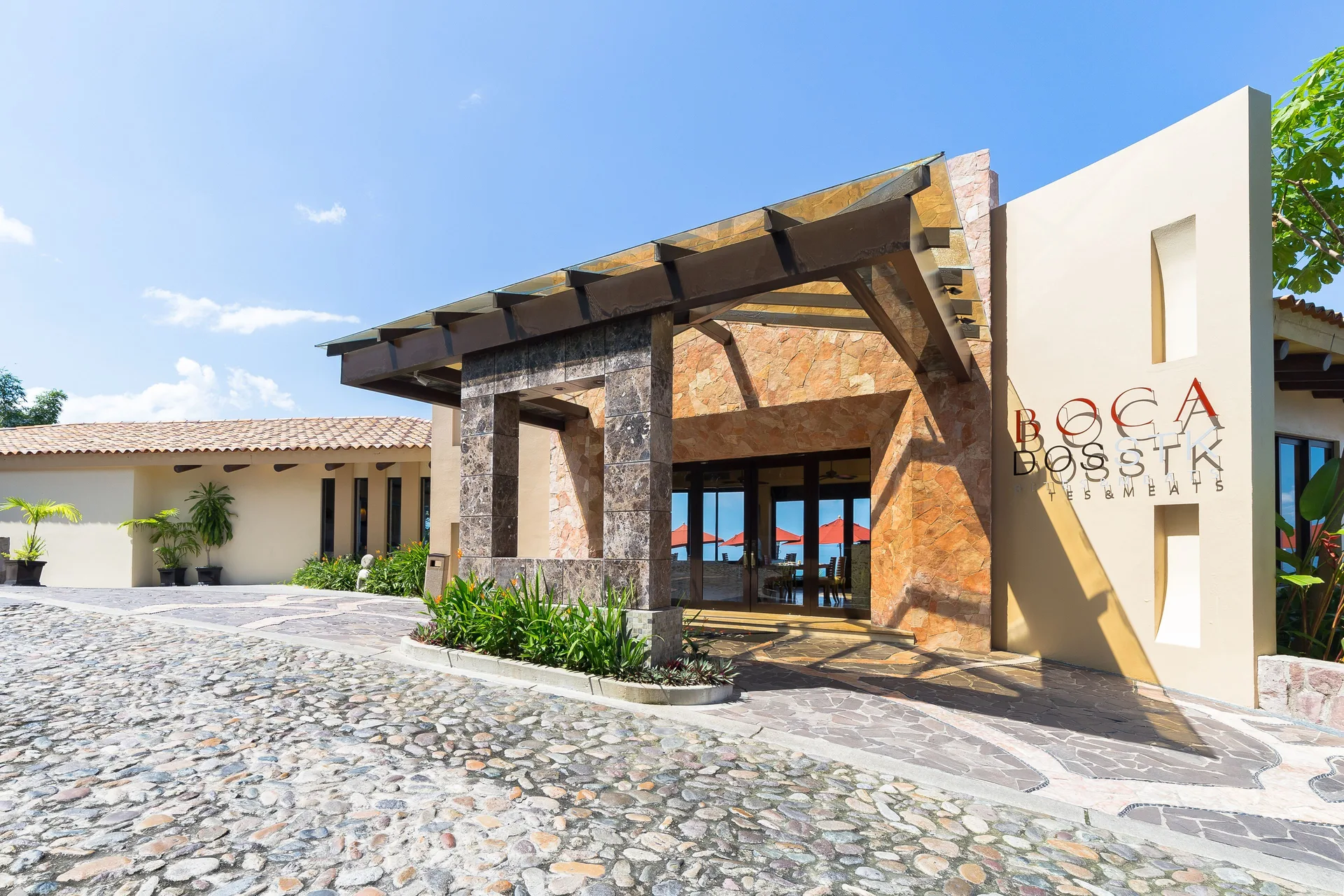 Bocados Steakhouse entrance with stone facade at Garza Blanca Preserve Resort & Spa.