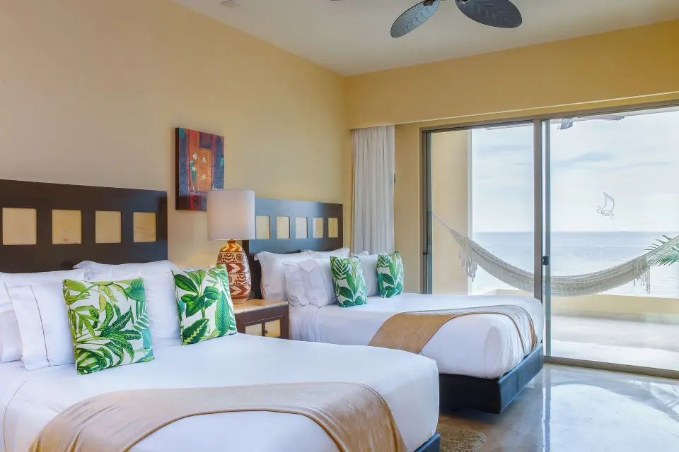 Deluxe room with two beds and ocean-view balcony at Garza Blanca Preserve Resort & Spa.