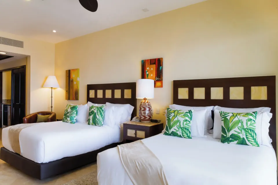 Deluxe two-bed room with tropical pillows at Garza Blanca Preserve Resort & Spa.