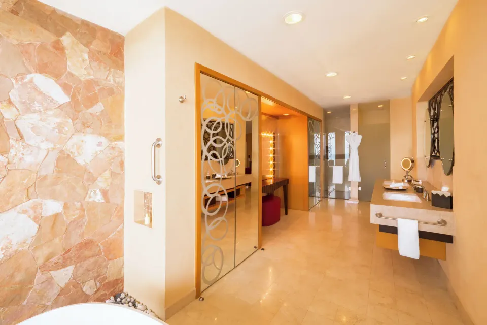 Junior Panoramic Suite bathroom with tub, vanities, and glass shower at Garza Blanca Preserve Resort & Spa.