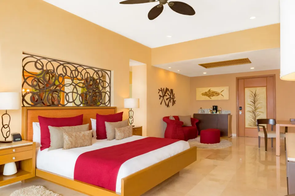 Junior Panoramic Suite king bed with entry and seating area at Garza Blanca Preserve Resort & Spa.