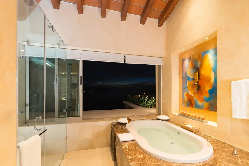 Oceanfront Penthouse bathroom with tub by a large window at Garza Blanca Preserve Resort & Spa.