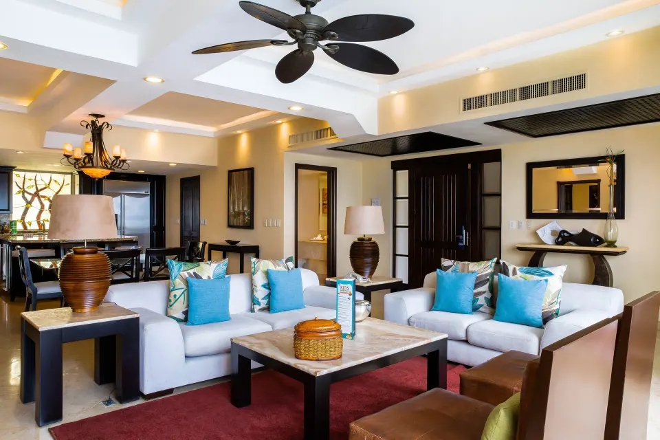Oceanfront Penthouse living area at Garza Blanca Preserve Resort & Spa with white sofas and blue pillows.