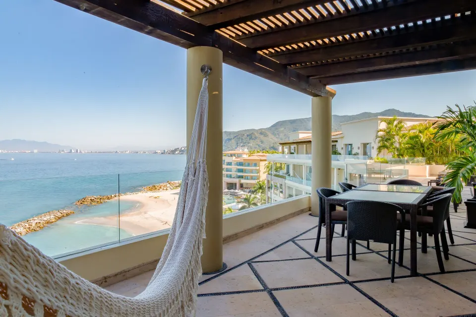 Oceanfront Penthouse terrace at Garza Blanca Preserve Resort & Spa with hammock, dining table, and bay view.