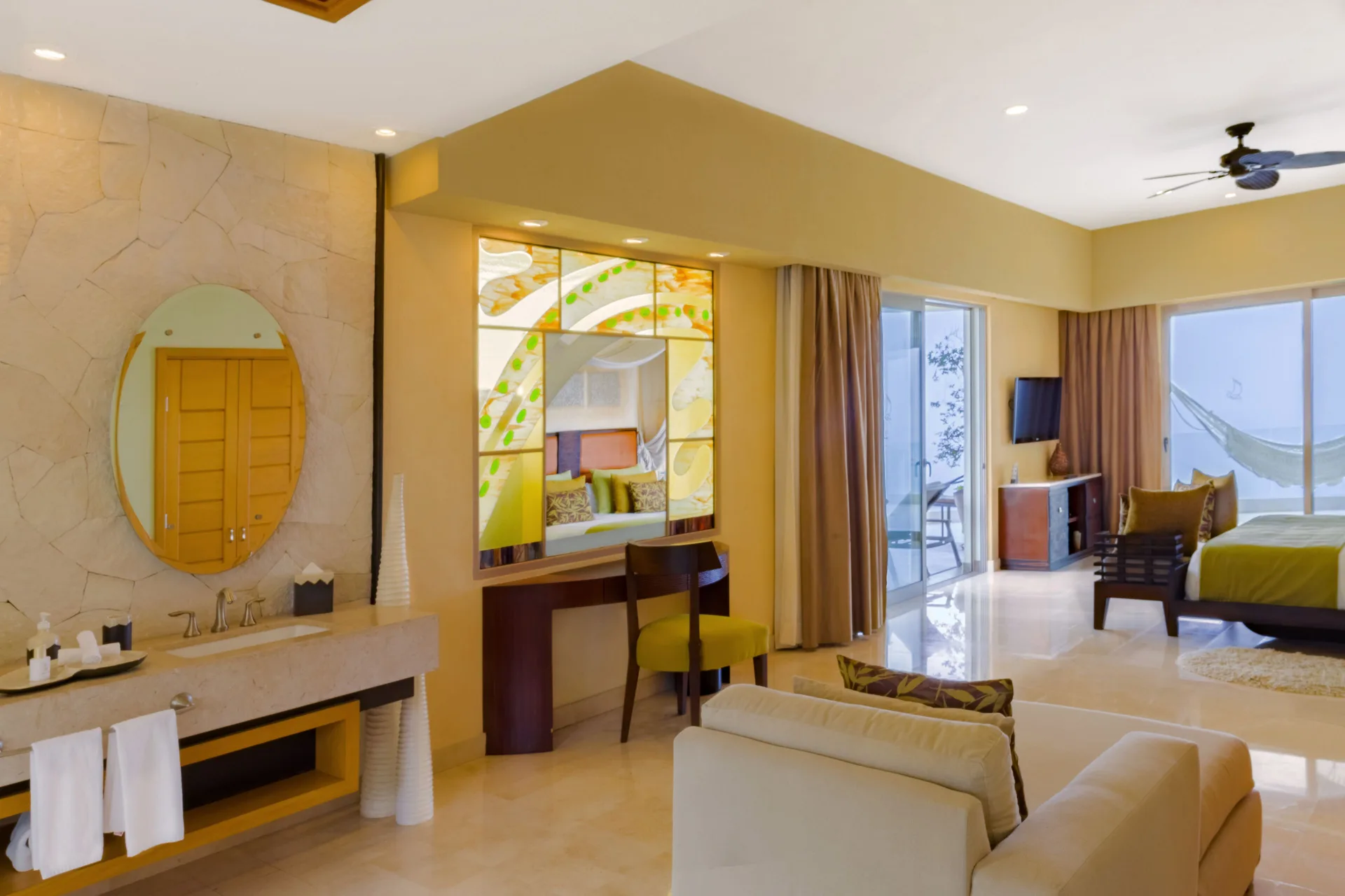 Two Bedroom Panoramic Suite bedroom, vanity, sofa, and balcony at Garza Blanca Preserve Resort & Spa.
