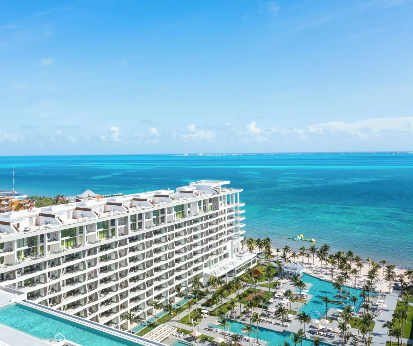 Aerial view of the resort towers, pools, beach, and turquoise sea at Garza Blanca Resort & Spa Cancun.