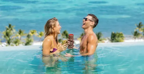 Couple enjoying drinks in the pool at Garza Blanca Resort & Spa Cancun.