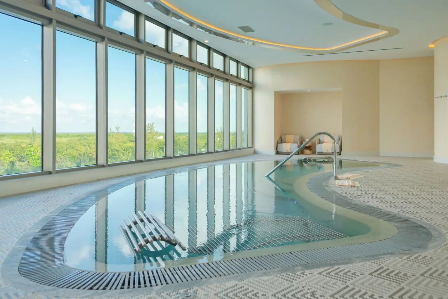 Indoor spa pool with floor-to-ceiling windows at Garza Blanca Resort & Spa Cancun.