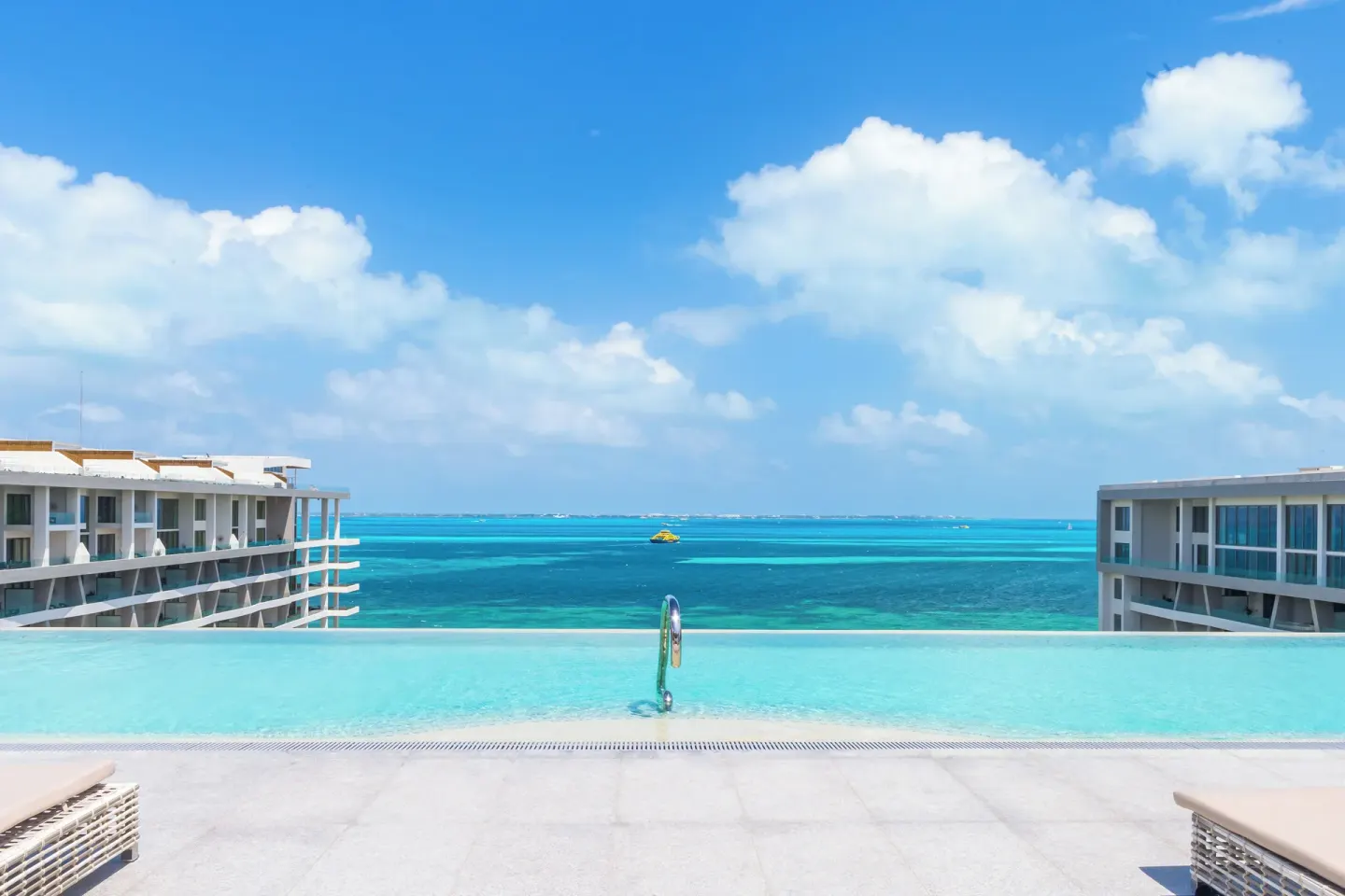 Infinity pool edge between resort wings at Garza Blanca Resort & Spa Cancun.