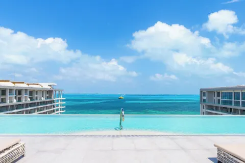 Infinity pool edge between resort wings at Garza Blanca Resort & Spa Cancun.