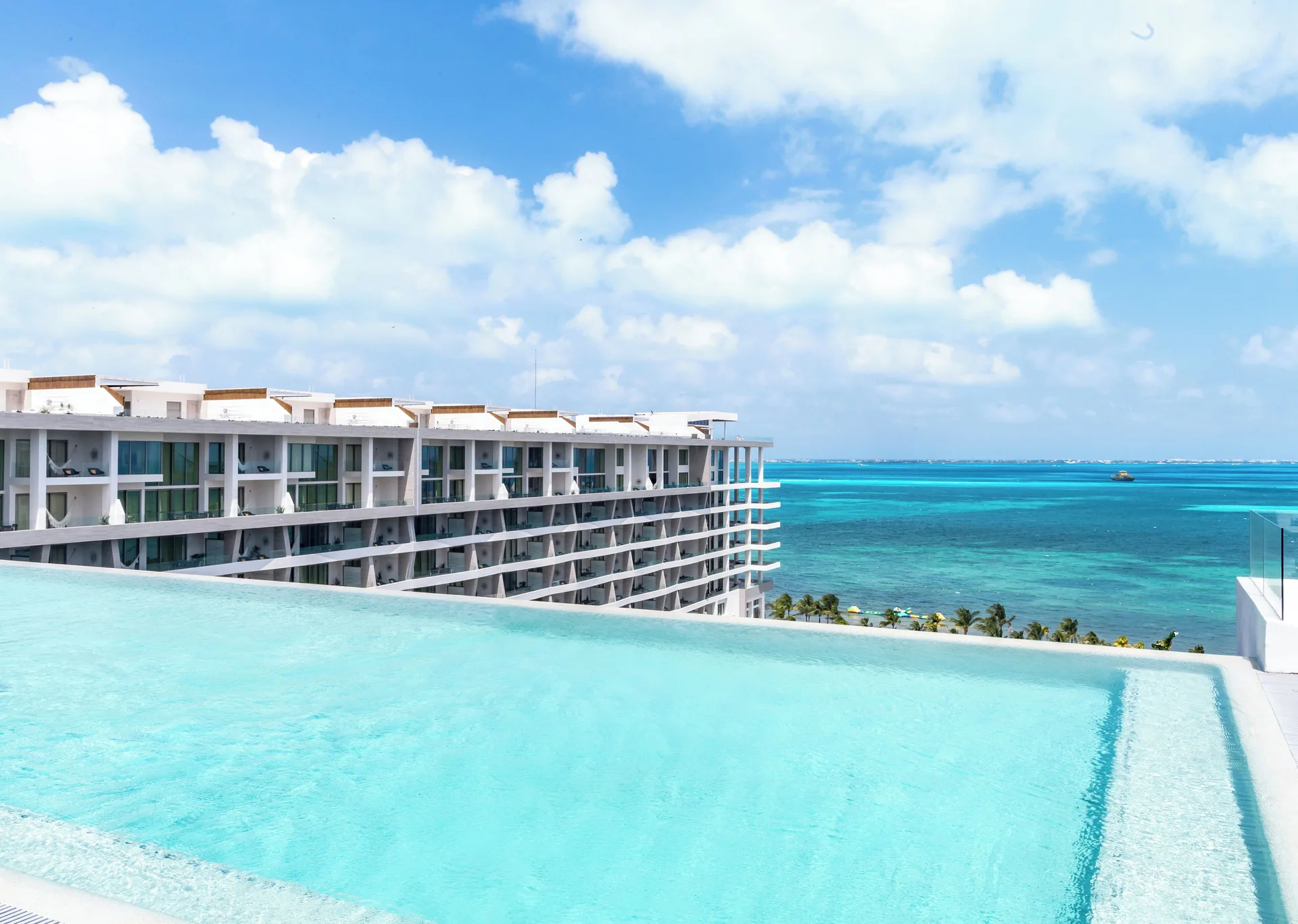Infinity pool overlooking turquoise water at Garza Blanca Resort & Spa Cancun.