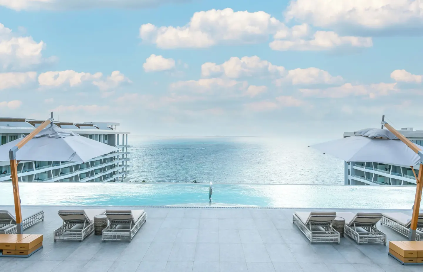 Pool terrace with loungers and umbrellas at Garza Blanca Resort & Spa Cancun.
