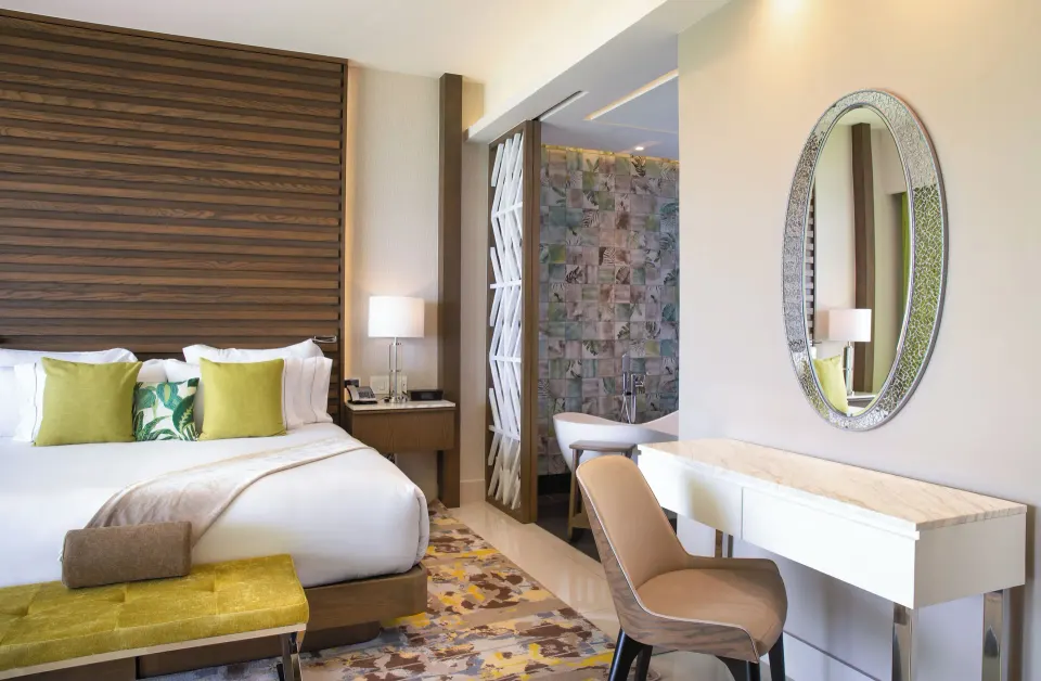 Junior Suite Ocean View king bed, vanity, and tub at Garza Blanca Resort & Spa Cancun.