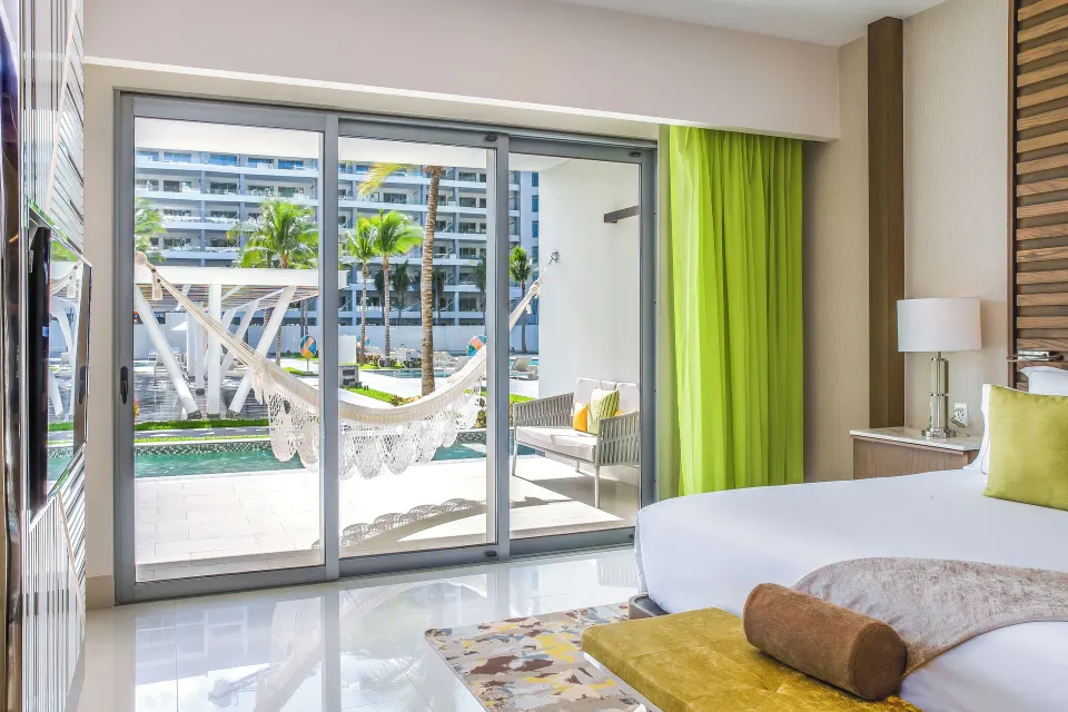 Junior Suite Swim Up king bed and terrace view at Garza Blanca Resort & Spa Cancun.
