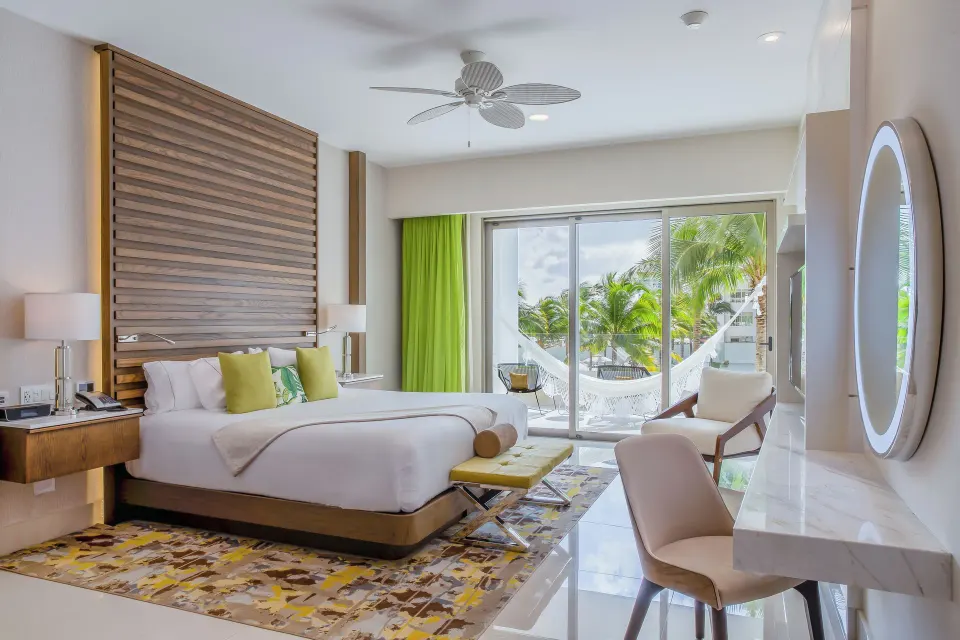Junior Suite king bed with balcony hammock and palm view at Garza Blanca Resort & Spa Cancun.