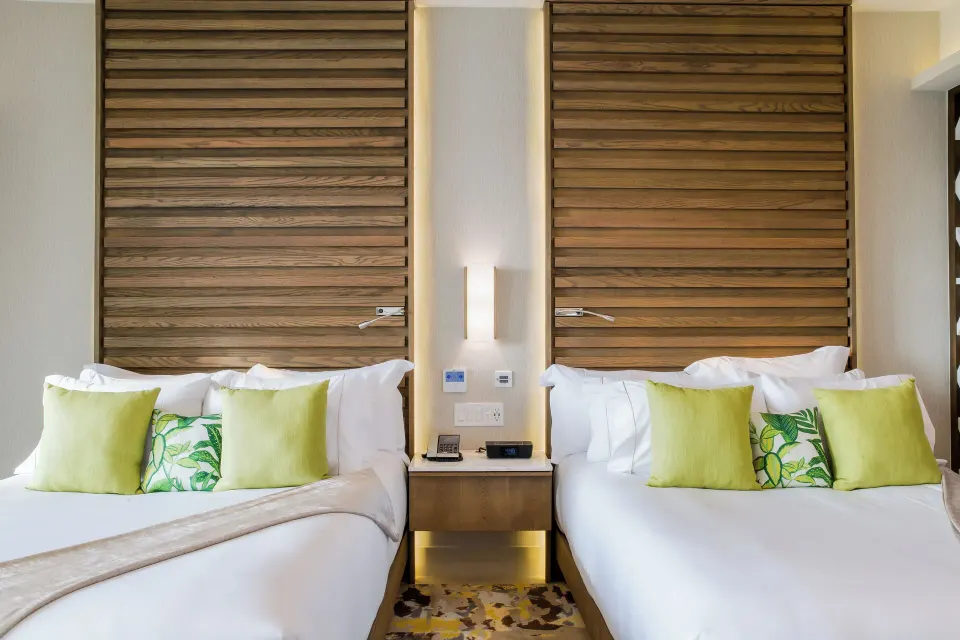 Junior Suite with two beds and tall wood-slat headboards at Garza Blanca Resort & Spa Cancun.