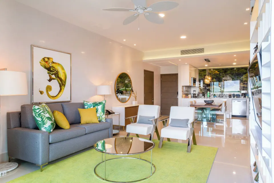 One Bedroom Suite living room with sofa and kitchen at Garza Blanca Resort & Spa Cancun.