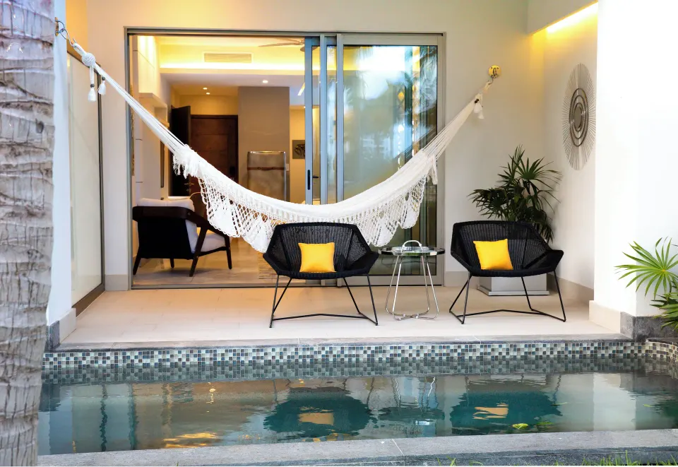 Private swim-up terrace with hammock and chairs at Garza Blanca Resort & Spa Cancun.