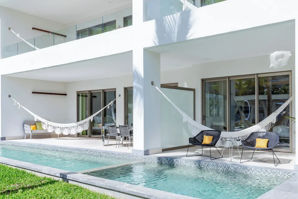 Swim-up terraces with hammocks outside One Bedroom Swim Up suites at Garza Blanca Resort & Spa Cancun.