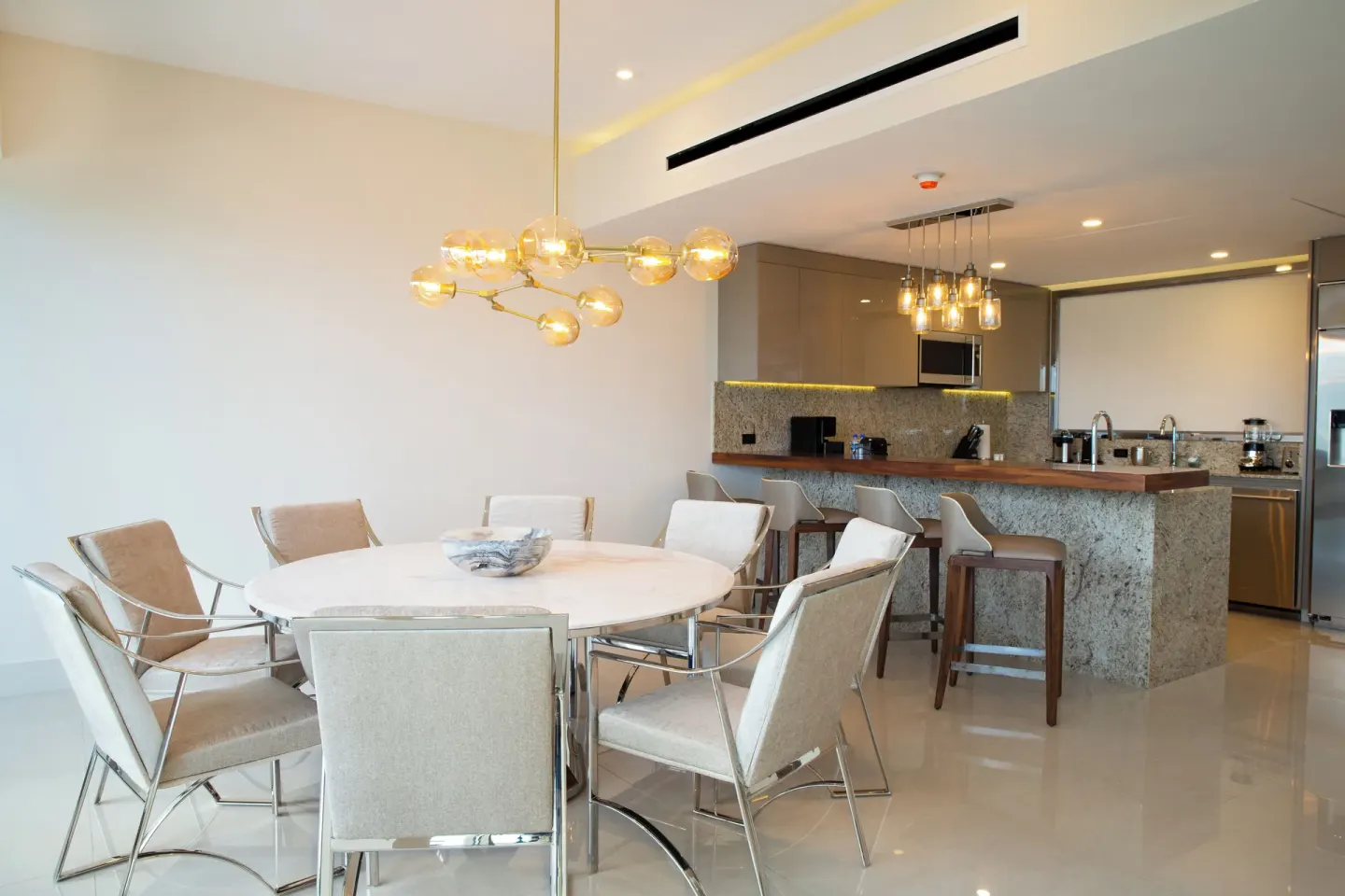 Dining table and open kitchen in the Three Bedroom Loft at Garza Blanca Resort & Spa Cancun.