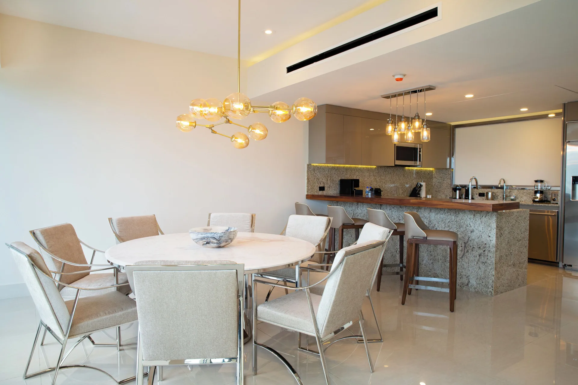 Dining table and open kitchen in the Three Bedroom Loft at Garza Blanca Resort & Spa Cancun.