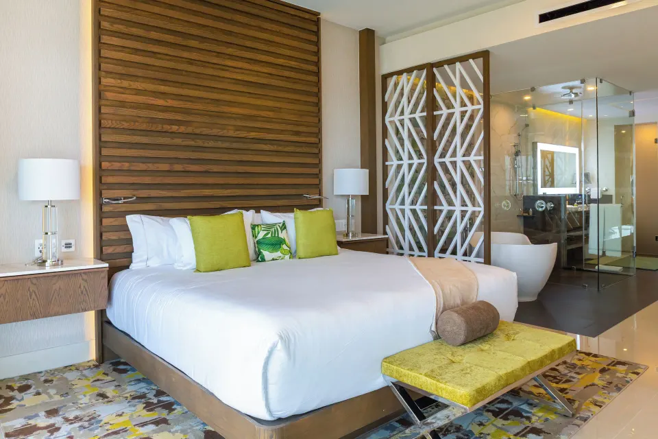 King bed with an open bathroom area in the Three Bedroom Loft at Garza Blanca Resort & Spa Cancun.
