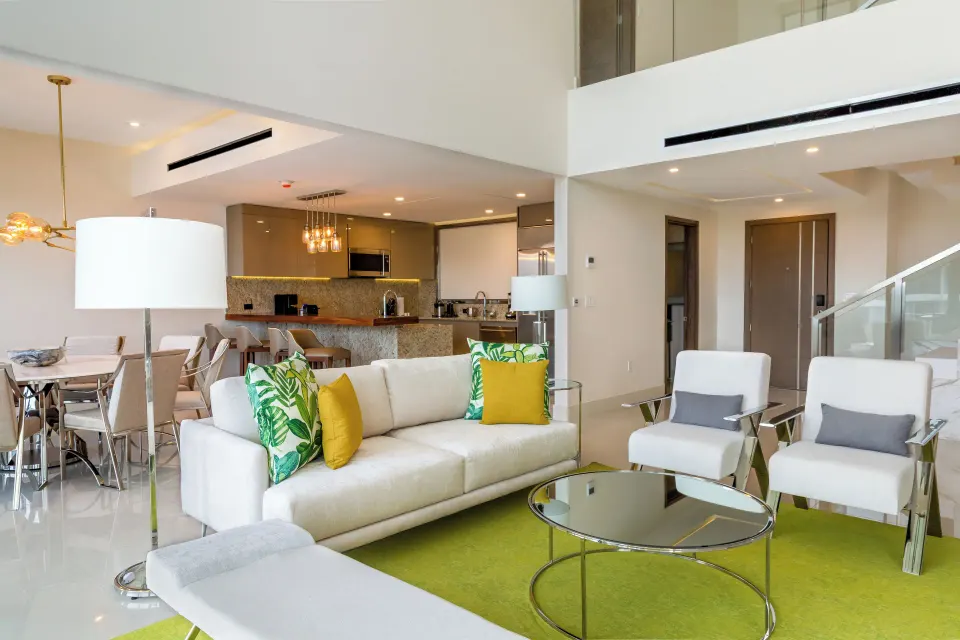 Living room, dining area, and stairs in a Three Bedroom Loft at Garza Blanca Resort & Spa Cancun.