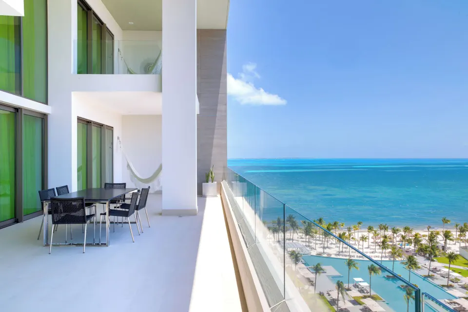 Ocean-view balcony with dining table at the Three Bedroom Loft at Garza Blanca Resort & Spa Cancun.