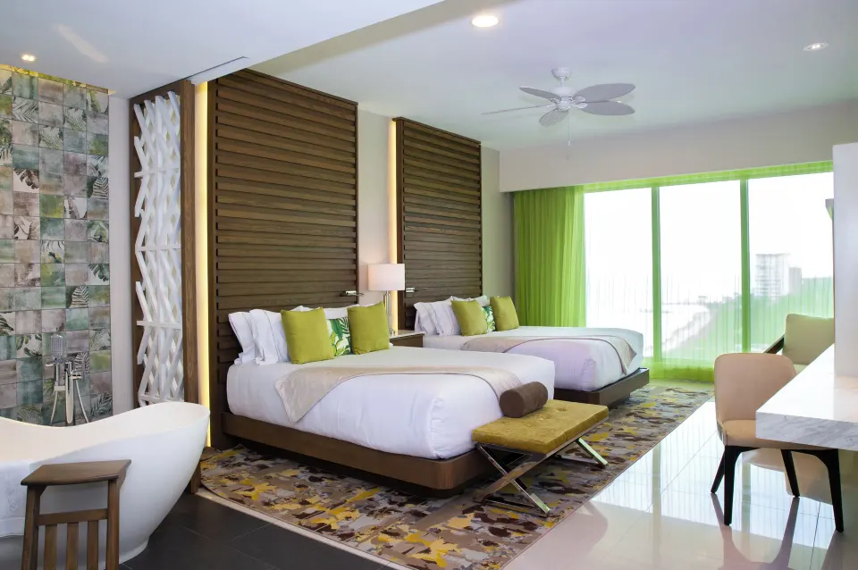 Two double beds and freestanding tub in a Three Bedroom Loft at Garza Blanca Resort & Spa Cancun.