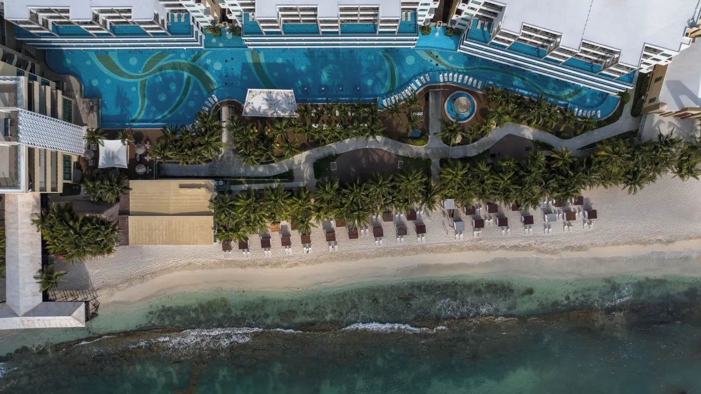 Top-down aerial of the pool, palms, beach, and shoreline at Generations Riviera Maya.