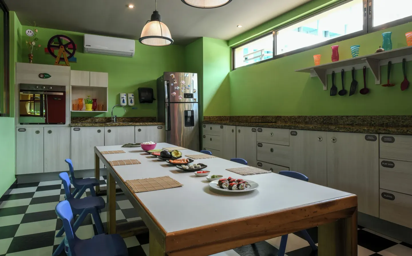 A children's cooking classroom with a long table at Generations Riviera Maya.