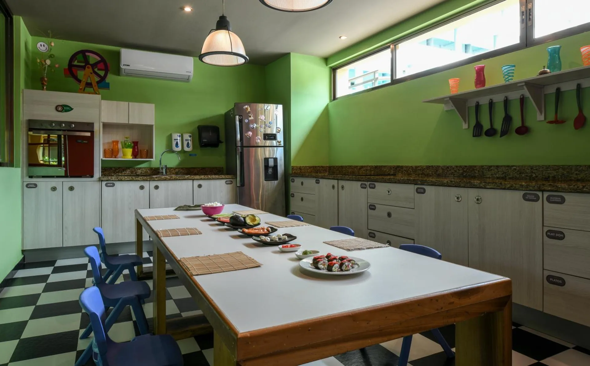 Colorful children’s kitchen classroom with small chairs and a long table at Generations Riviera Maya.