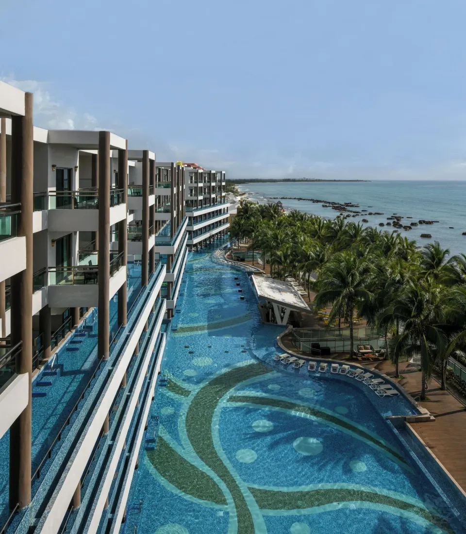 Oceanfront pool and balcony-lined buildings at Generations Riviera Maya.